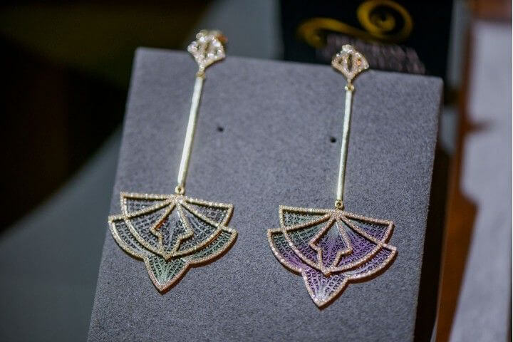 Earrings in 19.2k gold and diamonds from the Couture Collection on an Arneiro display case.